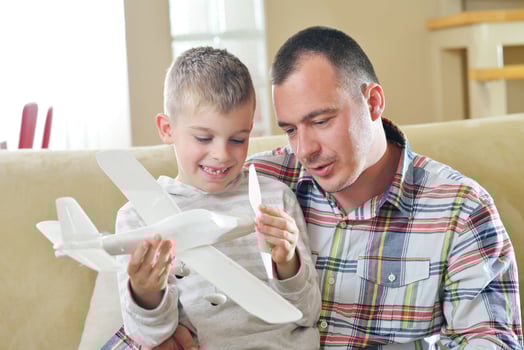 father and son assembling airplane toy photo