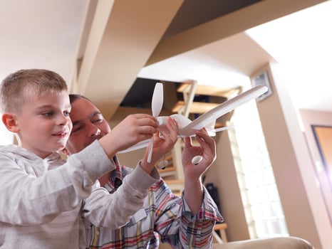 father and son assembling airplane toy photo