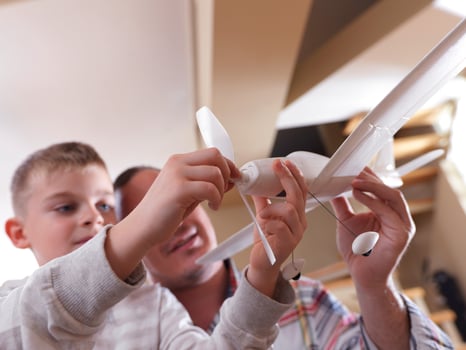 father and son assembling airplane toy photo