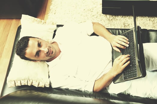 Portrait of a relaxed young guy using laptop at home photo