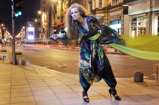 elegant woman on city street at night photo