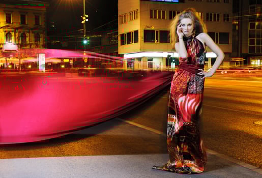 elegant woman on city street at night photo