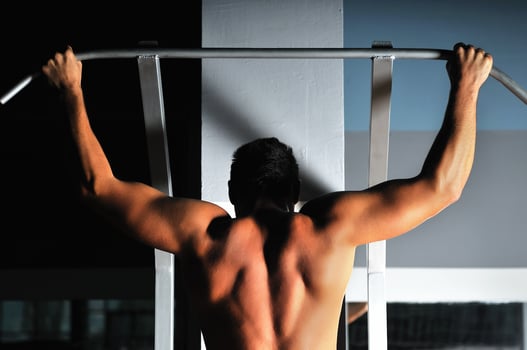 young man with strong arms working out in gym photo