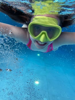 Smiling child in goggles swim, dive in the pool with fun - jump deep down underwater. Healthy lifestyle, people water sport activity on summers. photo