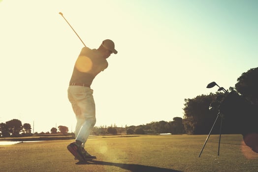 golf player hitting shot with club photo