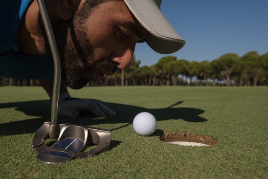 golf player blowing ball in hole photo
