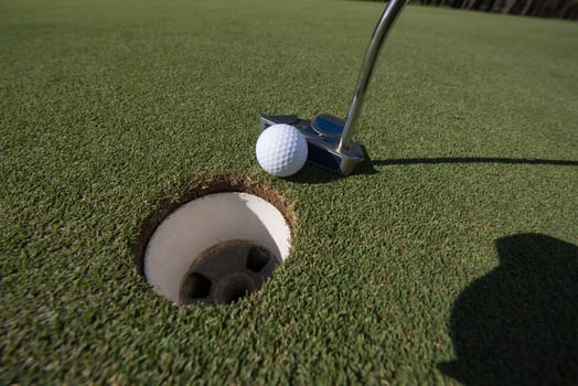 hitting golf ball to hole photo