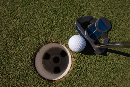 hitting golf ball to hole photo