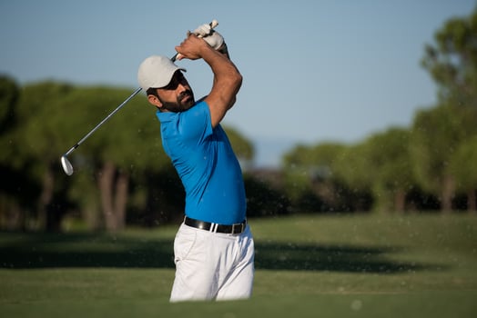 pro golfer hitting a sand bunker shot photo