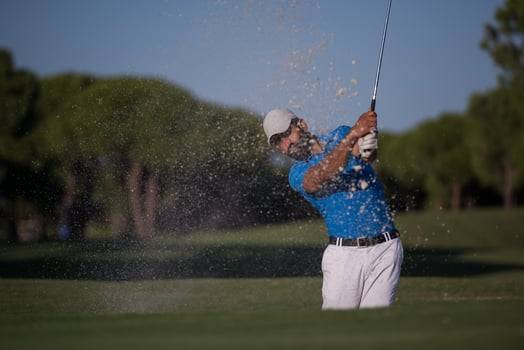 pro golfer hitting a sand bunker shot photo
