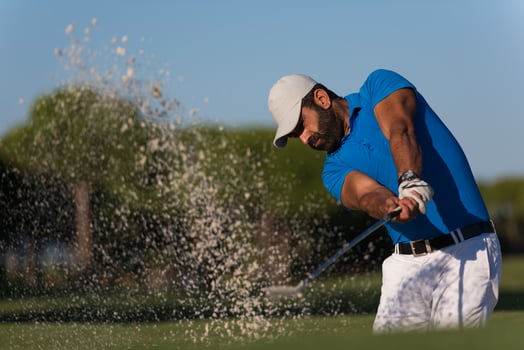 pro golfer hitting a sand bunker shot photo