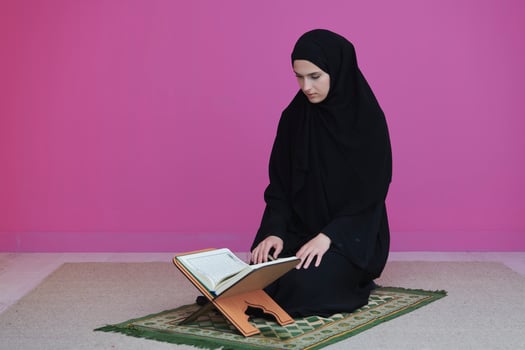 Middle eastern woman praying and reading the holy Quran photo