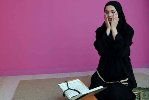 Middle eastern woman praying and reading the holy Quran photo