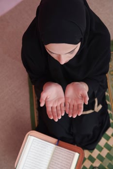 Middle eastern woman praying and reading the holy Quran photo