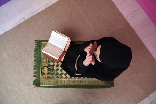 Middle eastern woman praying and reading the holy Quran photo