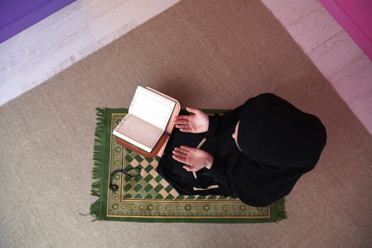 Middle eastern woman praying and reading the holy Quran photo