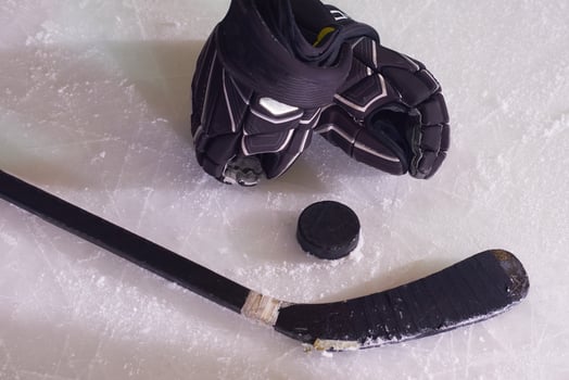 hockey sticsk and puck on ice photo