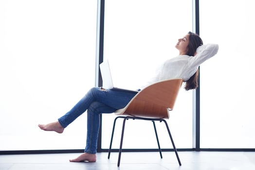 relaxed young woman at home working on laptop computer photo