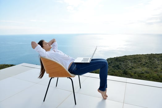 relaxed young woman at home working on laptop photo