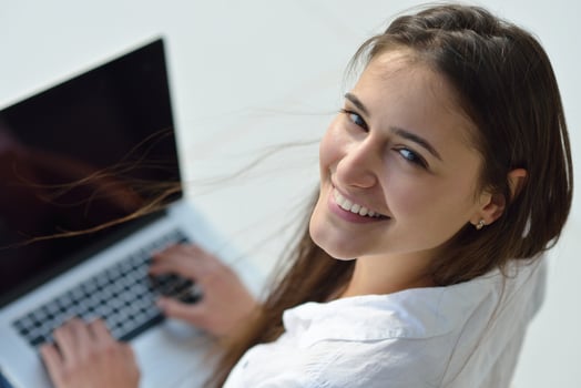 relaxed young woman at home working on laptop computer photo