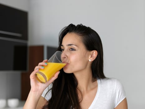 woman drinking juice in her kitchen photo