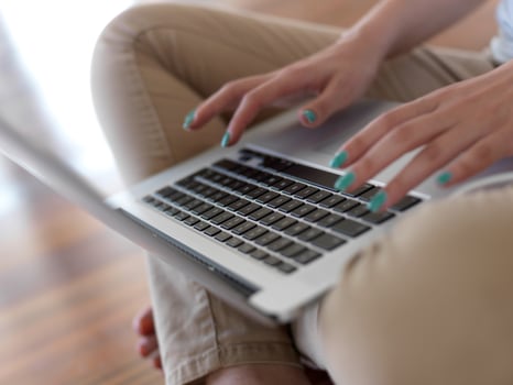 relaxed young woman at home working on laptop computer photo