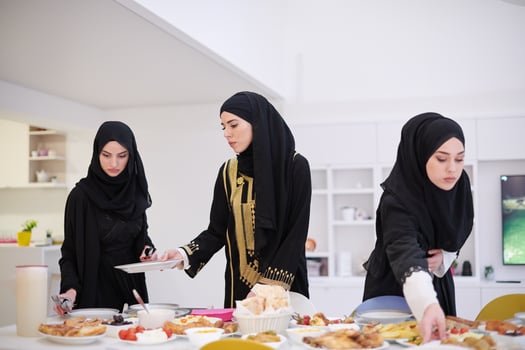 young muslim girls serving food on the table for iftar dinner photo