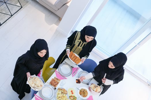 young muslim girls serving food on the table for iftar dinner top view photo