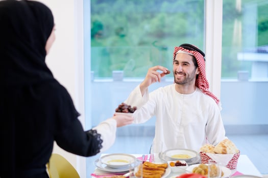 Muslim family having Iftar dinner eating dates to break feast photo