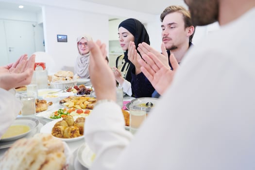 traditional muslim family praying before iftar dinner photo