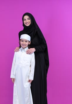 portrait of muslim mother and son on pink background photo