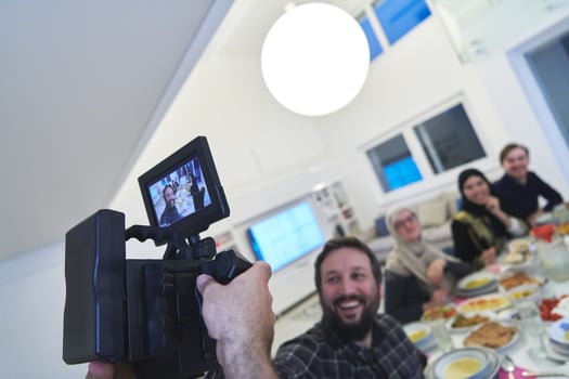 Professional videograph recording video while Muslim family having iftar together during Ramadan photo