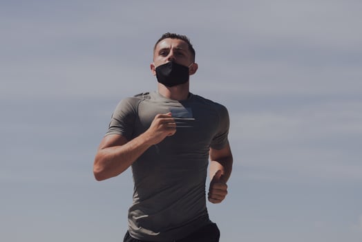 Young man and woman in protective masks running and doing exercises outdoors in the morning. Sport, Active life Jogging during quarantine. Covid-19 new normal. High quality photo. Selective focus. photo