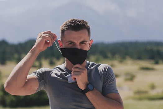 Young man and woman in protective masks running and doing exercises outdoors in the morning. Sport, Active life Jogging during quarantine. Covid-19 new normal. High quality photo. Selective focus. photo