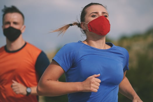 couple running in nature wearing mask photo
