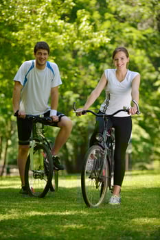 Happy couple riding bicycle outdoors photo