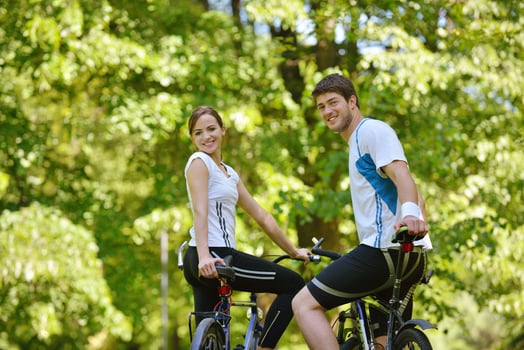 Happy couple riding bicycle outdoors photo