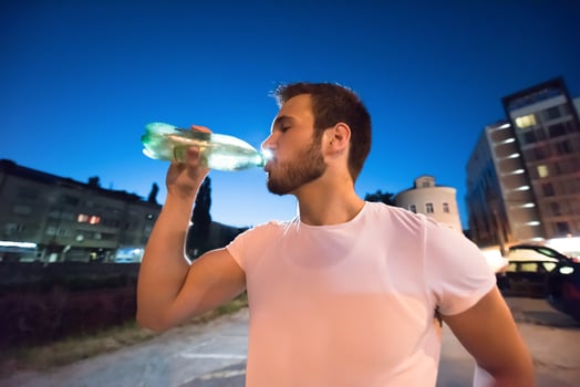 man drinking water after running session photo