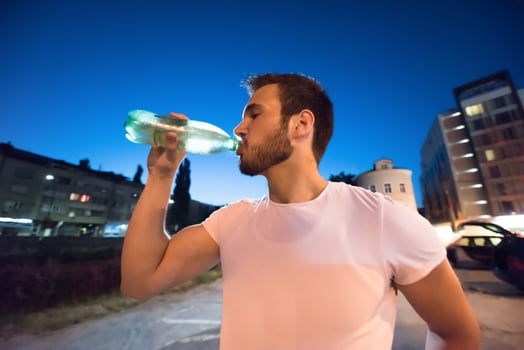 man drinking water after running session photo