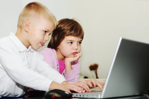 childrens have fun and playing games on laptop computer photo