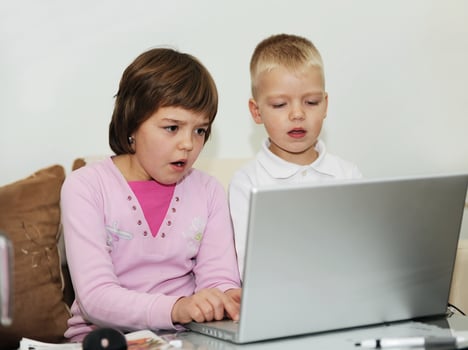 childrens have fun and playing games on laptop computer photo