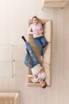 Young couple on the sofa watching television top view photo