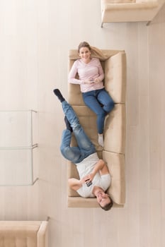 Young couple on the sofa watching television top view photo