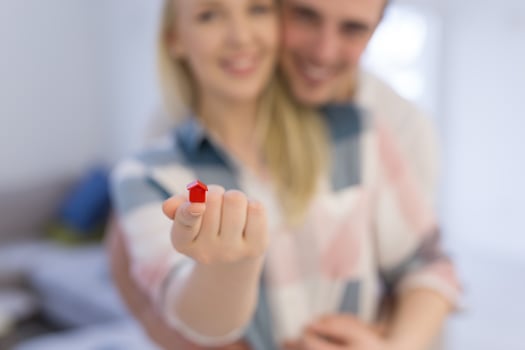 couple showing small red house in hands photo