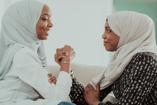African woman arm wrestling conflict concept, disagreement and confrontation wearing traditional islamic hijab clothes. Selective focus photo