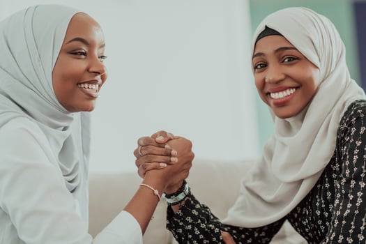 African woman arm wrestling conflict concept, disagreement and confrontation wearing traditional islamic hijab clothes. Selective focus photo