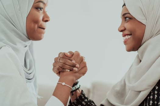 African woman arm wrestling conflict concept, disagreement and confrontation wearing traditional islamic hijab clothes. Selective focus photo