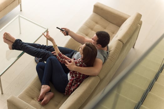 Young couple on the sofa watching television photo