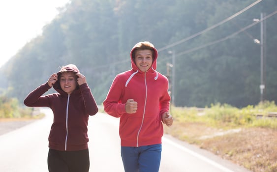 young couple jogging along a country road photo