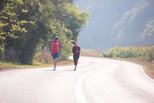 young couple jogging along a country road photo